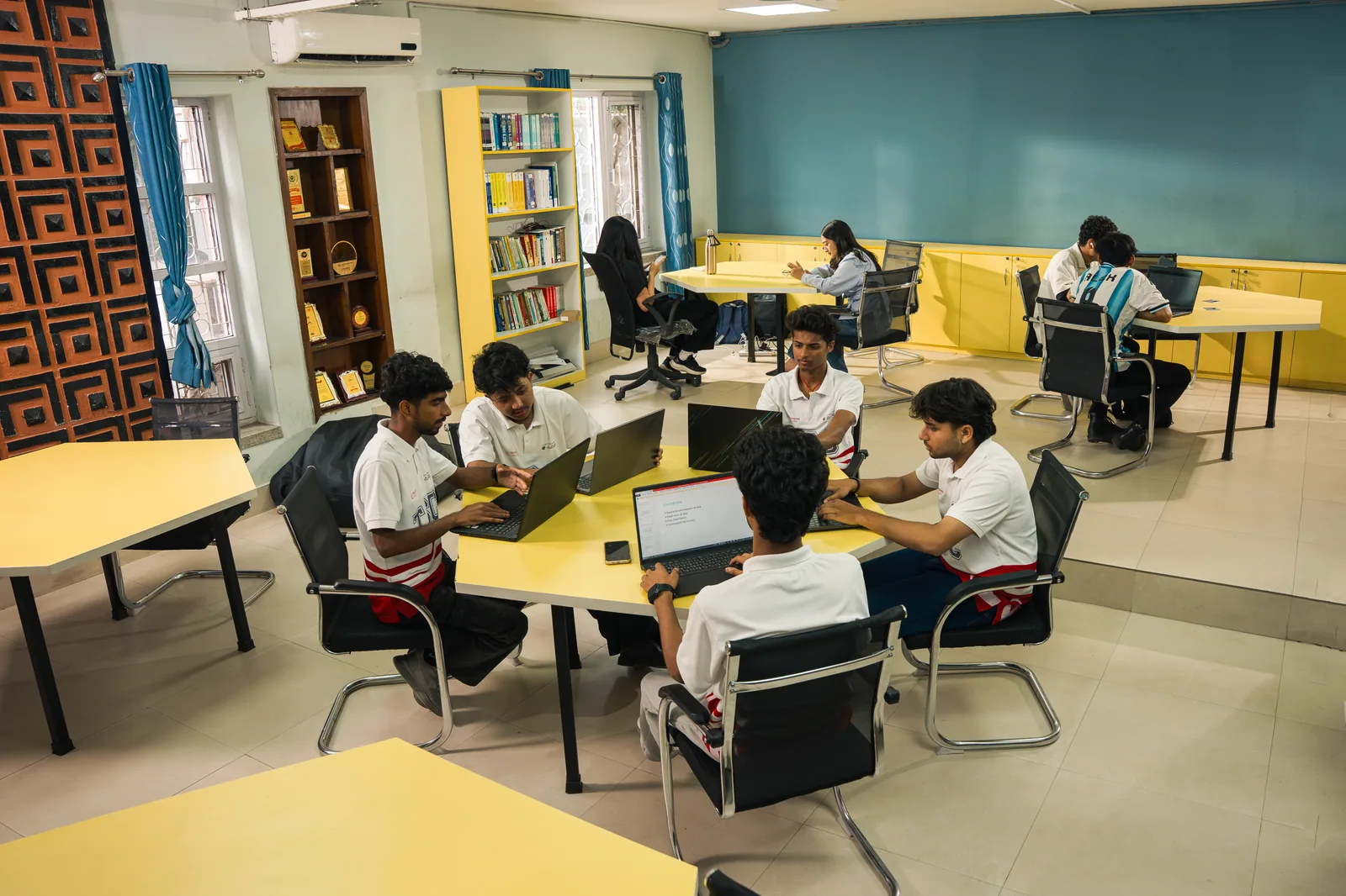 Techspire students collaborating with laptops inside the campus learning space