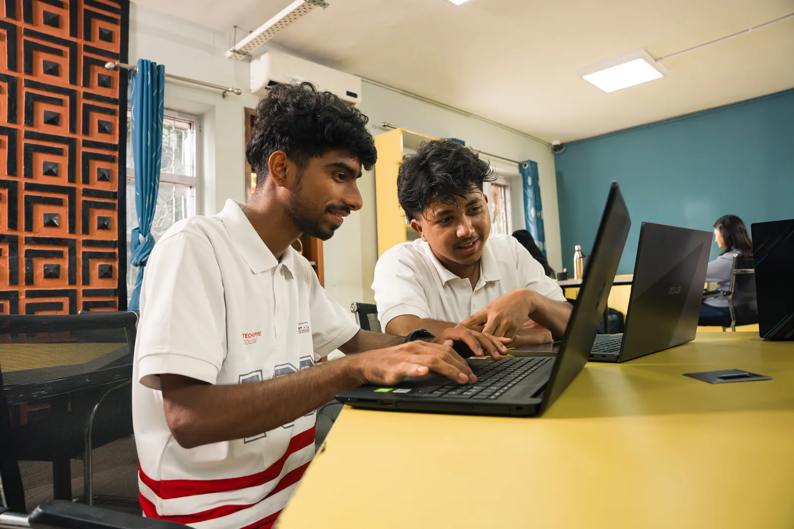 Techspire students working together on a laptop in class