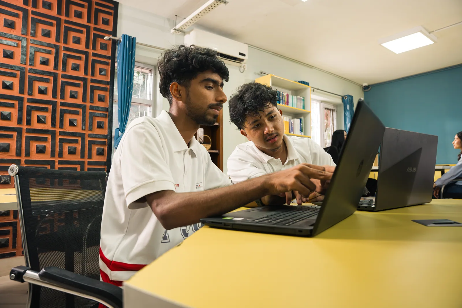Techspire students discussing a laptop project together